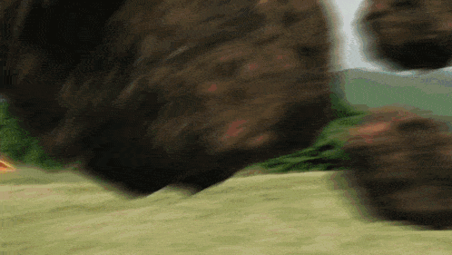 a blurred image of a bear 's legs running on a grassy field