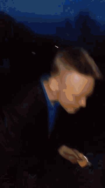 a person is wearing a hat and covering their face with it .