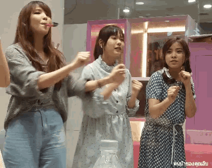three girls are dancing in front of a mirror with the words " คน บ้าน ของ คุณ " written on the bottom