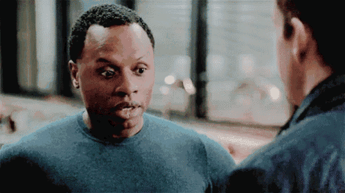 a man in a blue shirt is talking to another man in a blue shirt .
