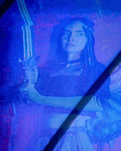 a woman is holding a sword in front of a blue screen