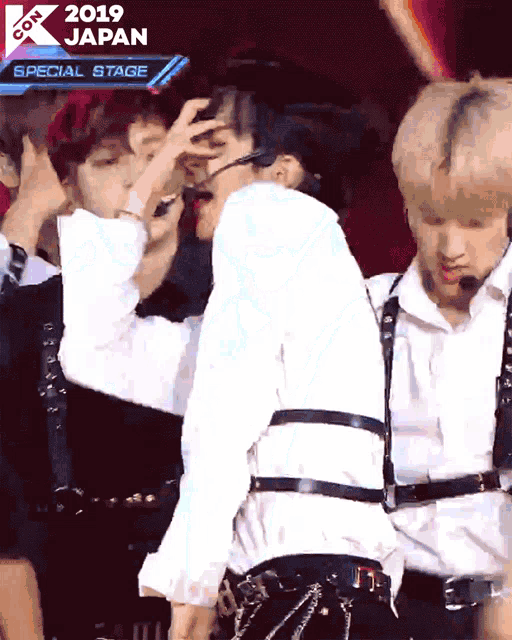 a group of young men are performing on a special stage at a k-pop concert in japan