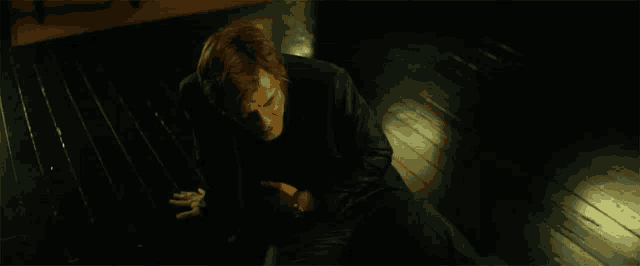 a man is sitting on the floor with his hands on his chest