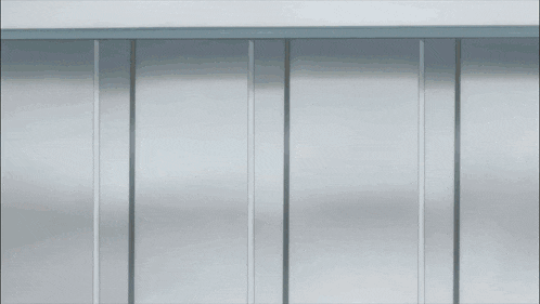a person in a suit and tie is sitting under a metal barrier