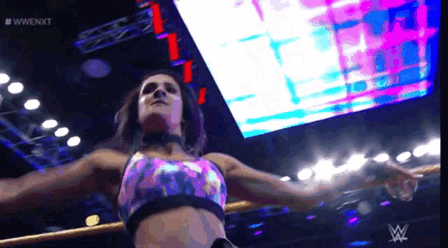 a woman in a wrestling ring with a w logo on the bottom