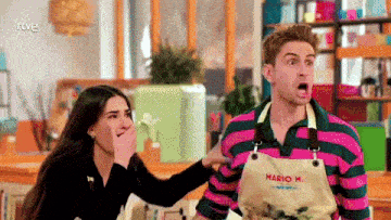 a man wearing an apron that says mario on it stands next to a woman