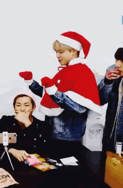 a man in a santa hat is standing next to two other men