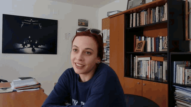 a woman wearing sunglasses and a blue shirt that says ' ny ' on it