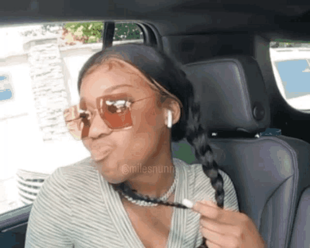a woman wearing sunglasses is sitting in the back seat of a car