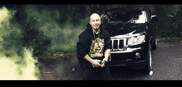 a man kneeling in front of a black jeep wearing a hoodie that says ' a ' on it