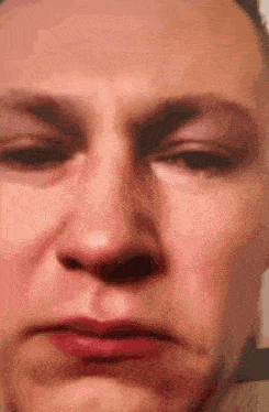 a close up of a woman 's face with red lips making a face .