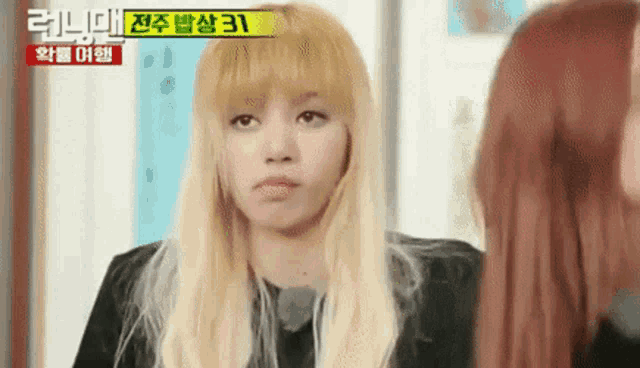 a woman with blonde hair is making a funny face while standing next to another woman .