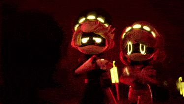 a couple of cartoon characters are standing next to each other in a dark room with glowing eyes .