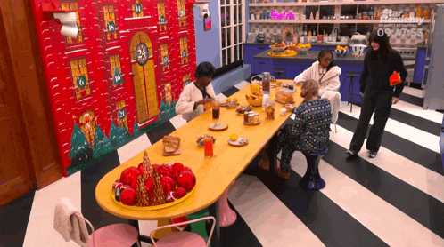 a group of people are sitting around a table with a calendar on the wall that has the number 24 on it