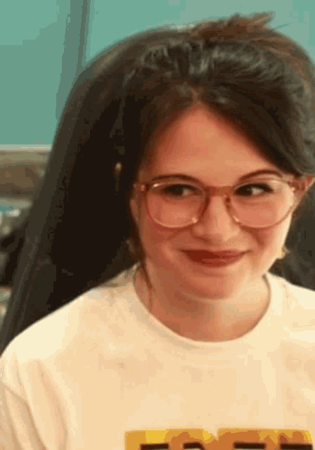 a woman wearing glasses and a white t-shirt with the word free on it