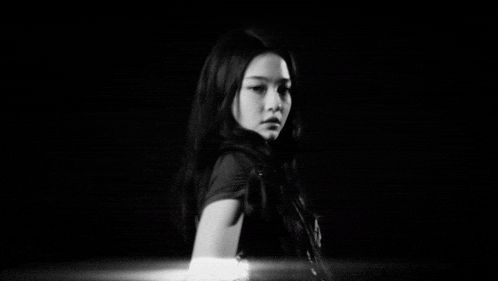 a black and white photo of a woman with long hair and a necklace that says calvin klein