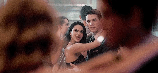 a man and a woman are dancing in a crowd at a party .
