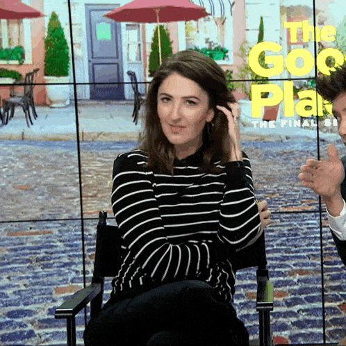 a woman in a striped shirt is sitting in front of a screen that says the go plan