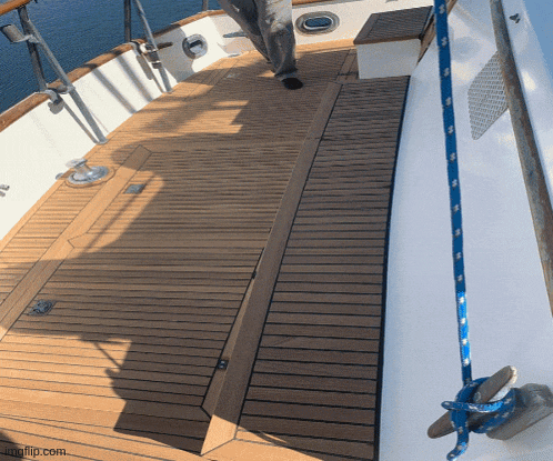 a wooden deck on a boat with a blue rope hanging from the side