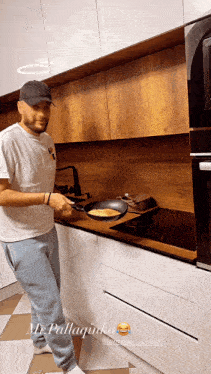 a man in a white shirt is cooking in a kitchen with the name pallagunka on the bottom