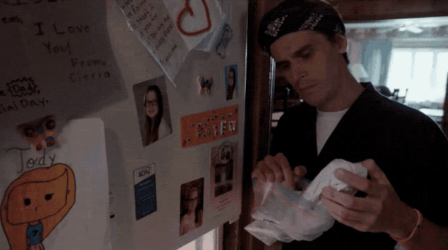 a man is standing in front of a fridge with a note on it that says i love you