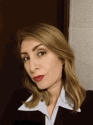 a woman with red lipstick on her lips looks down