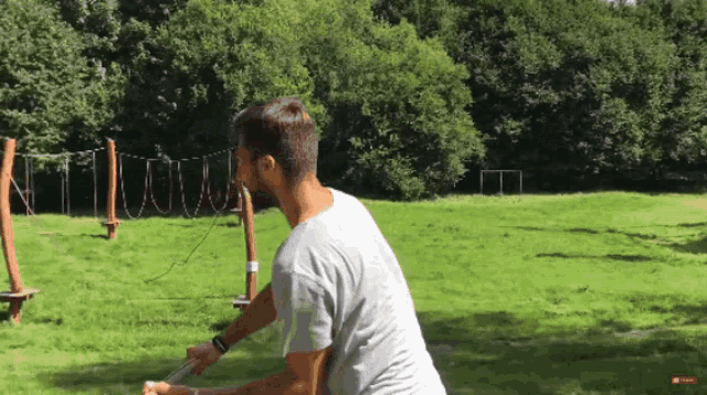 a man in a white shirt is standing in a park