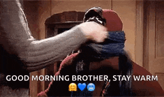 a person is putting a scarf on another person 's head and says `` good morning brother , stay warm '' .