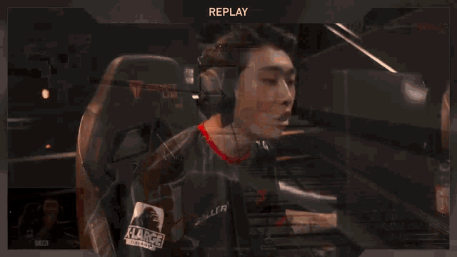 a man wearing headphones and a shirt that says " replay " on it