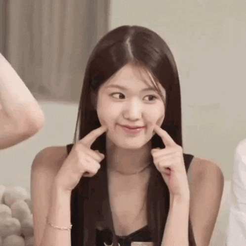 a woman is making a funny face with her fingers while looking at the camera .
