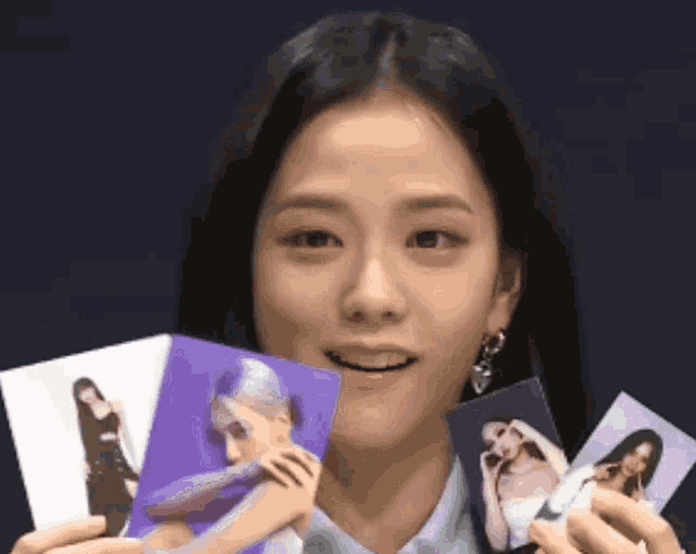 a woman is holding a bunch of pictures in her hands .