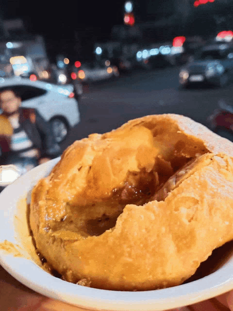 a person is holding a plate of food with a donut in it