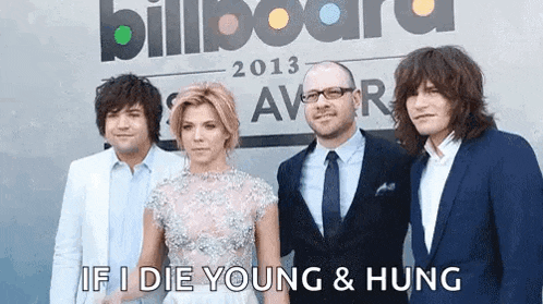 a group of people standing in front of a sign that says billboard 2013 award