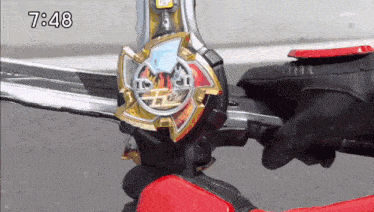 a person is holding a toy sword with the time 7:48 on the bottom