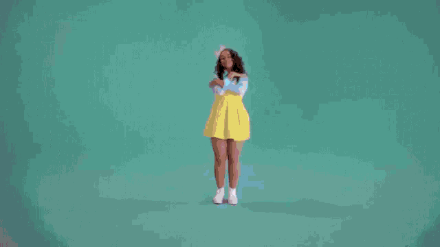 a man in a white shirt and blue shorts is dancing against a pink background .