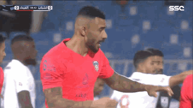 a soccer player in a red shirt with ssc on the bottom