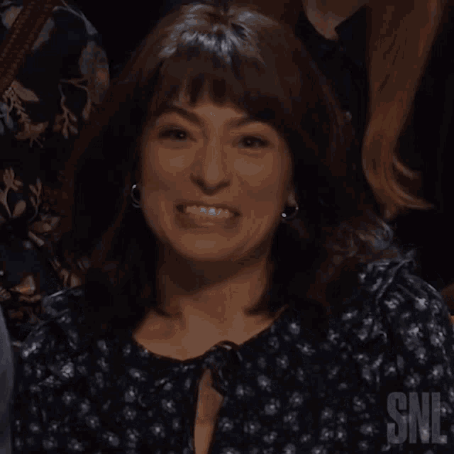 a woman in a polka dot dress is sitting in a snl audience