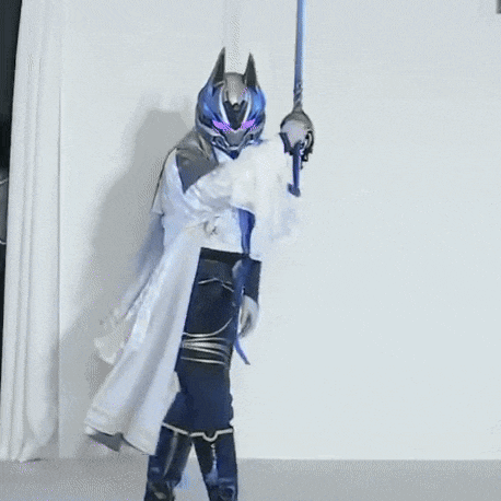a person dressed as a superhero is holding a sword and a helmet .