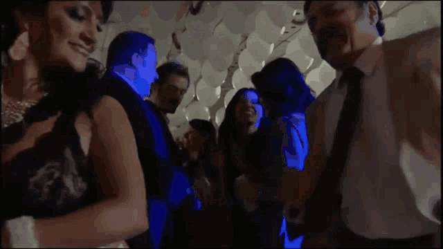 a group of people are dancing in a room filled with white balloons