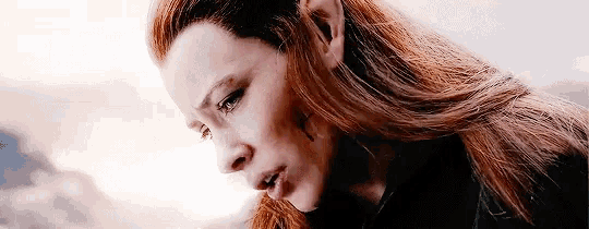 a woman with red hair and elf ears is crying .
