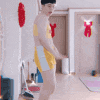 a man in a bathing suit is dancing in a room with a fan .