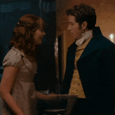 a man and a woman looking at each other in a room