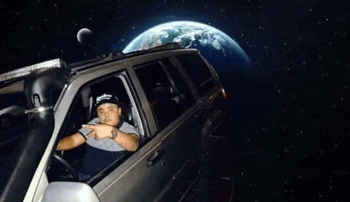 a man is sitting in a car in front of the earth in space .