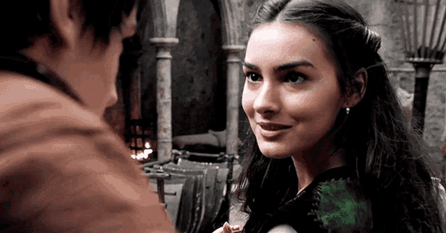a man and a woman are looking at each other in a castle .