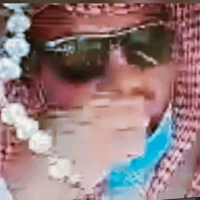 a close up of a man wearing sunglasses and a scarf on a computer screen .