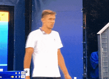 a man in a white shirt stands in front of a scoreboard that says 40 on it