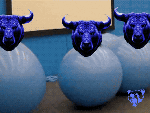 three blue bulls with horns are standing next to each other on blue balls