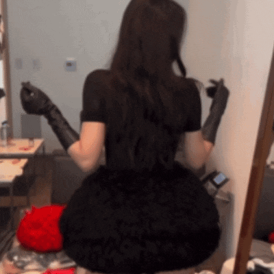 a woman wearing black gloves and a black dress