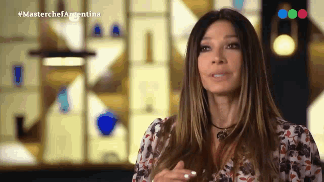 a woman in a floral shirt is on a tv show called master chef argentina