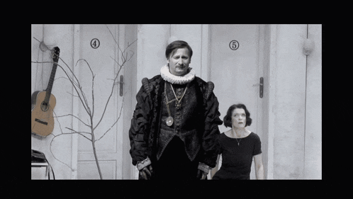 a black and white photo of a man and a woman standing in front of a door with the number 4 and 5 on it
